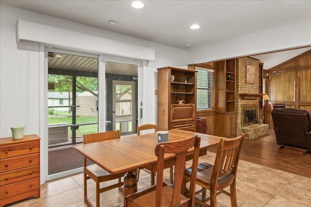 1601 Samoa Ct, Pflugerville, TX 78660 - dining room with a brick fireplace, light tile patterned floors, recessed lighting, and vaulted ceiling