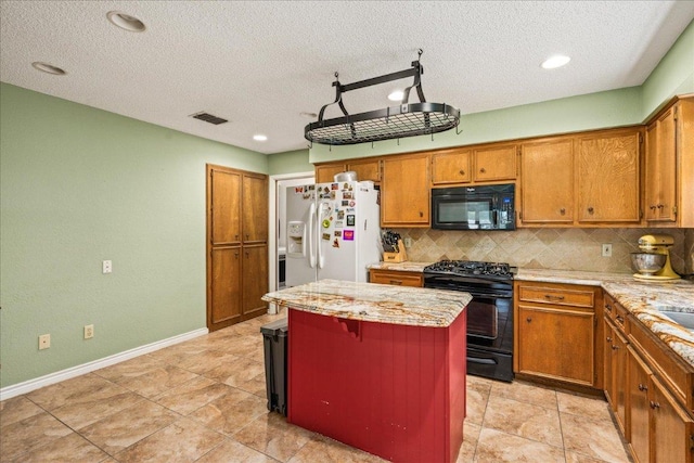 1601 Samoa Ct, Pflugerville, TX 78660 - kitchen featuring black appliances, backsplash, a center island, brown cabinets, and a textured ceiling