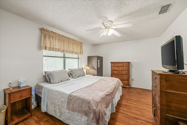1601 Samoa Ct, Pflugerville, TX 78660 - bedroom featuring wood finished floors, a textured ceiling, and ceiling fan
