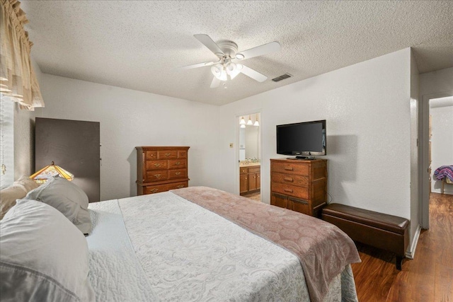 1601 Samoa Ct, Pflugerville, TX 78660 - bedroom featuring wood finished floors, a textured ceiling, a ceiling fan, and ensuite bath