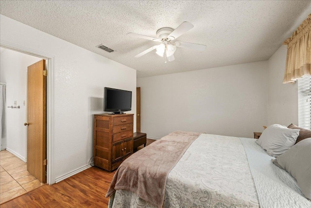 1601 Samoa Ct, Pflugerville, TX 78660 - bedroom with light wood finished floors, a textured ceiling, and ceiling fan