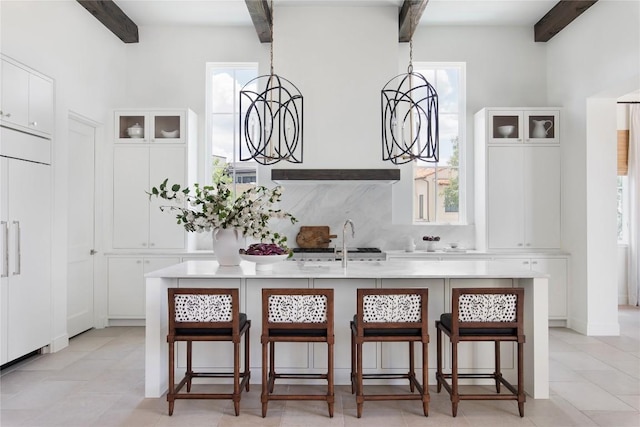 4401 Amarra Dr Unit 19, Austin, TX 78735 - kitchen with beam ceiling, light countertops, a kitchen breakfast bar, a kitchen island with sink, and paneled refrigerator