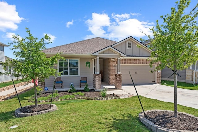 112 Wichita River Rd, Hutto, TX 78634 - view of front of home with driveway, covered porch, a garage, board and batten siding, and brick siding