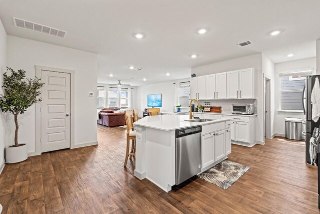112 Wichita River Rd, Hutto, TX 78634 - kitchen with dishwasher, dark wood finished floors, white cabinetry, a center island with sink, and recessed lighting