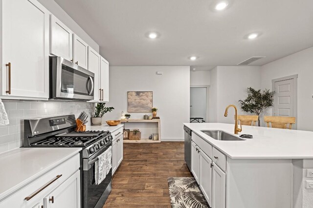 112 Wichita River Rd, Hutto, TX 78634 - kitchen featuring stainless steel appliances, backsplash, recessed lighting, dark wood-style flooring, and light countertops