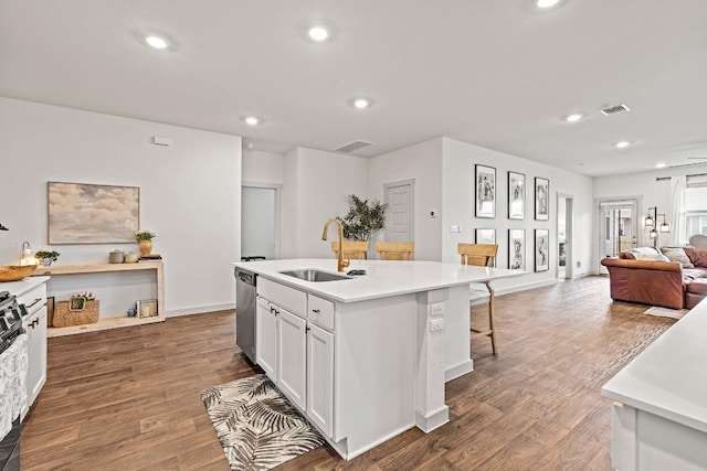 112 Wichita River Rd, Hutto, TX 78634 - kitchen featuring stainless steel dishwasher, open floor plan, recessed lighting, wood finished floors, and light countertops
