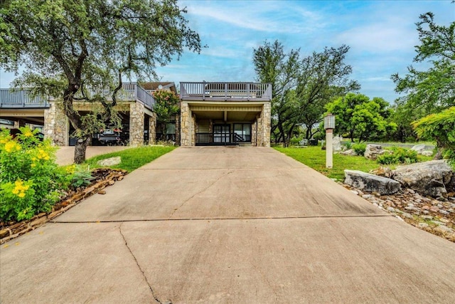 501 Highlands Blvd Unit 13, Horseshoe Bay, TX 78657 - view of front facade featuring stone siding, concrete driveway, a balcony, and a carport