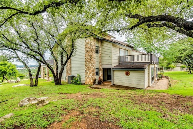 501 Highlands Blvd Unit 13, Horseshoe Bay, TX 78657 - rear view of house featuring a balcony, a yard, and stone siding