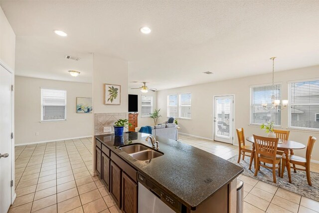 221 Pearl Way, Buda, TX 78610 - kitchen with light tile patterned floors, stainless steel dishwasher, a chandelier, ceiling fan, and decorative light fixtures