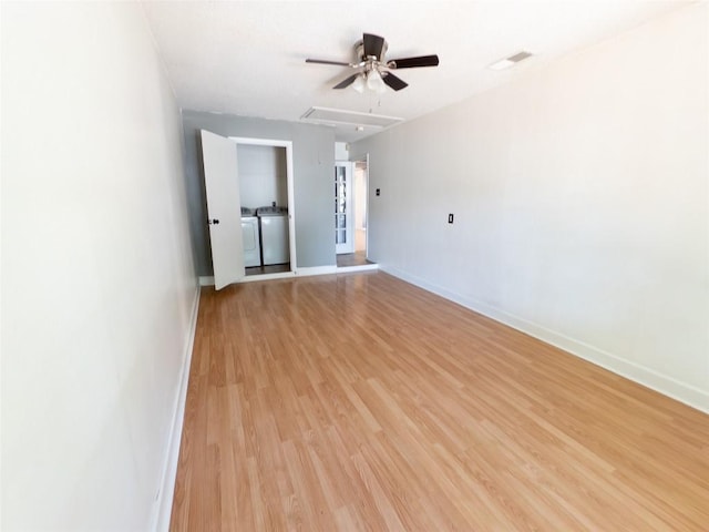 823 Topaz Ln, Leander, TX 78641 - empty room with a ceiling fan, separate washer and dryer, light wood-style flooring, and attic access