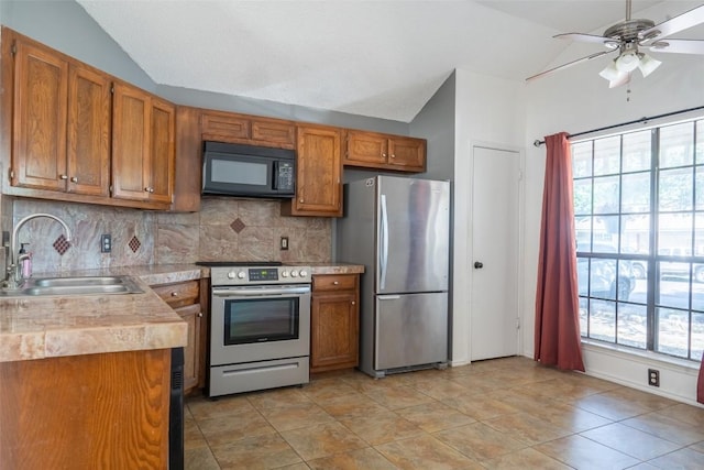 823 Topaz Ln, Leander, TX 78641 - kitchen with appliances with stainless steel finishes, lofted ceiling, brown cabinets, tasteful backsplash, and a ceiling fan
