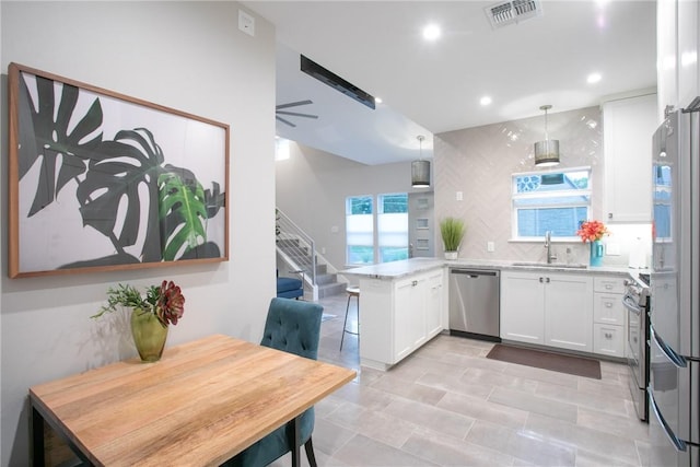 6613 Woodrow Ave, Austin, TX 78757 - kitchen featuring stainless steel appliances, a peninsula, white cabinets, recessed lighting, and backsplash
