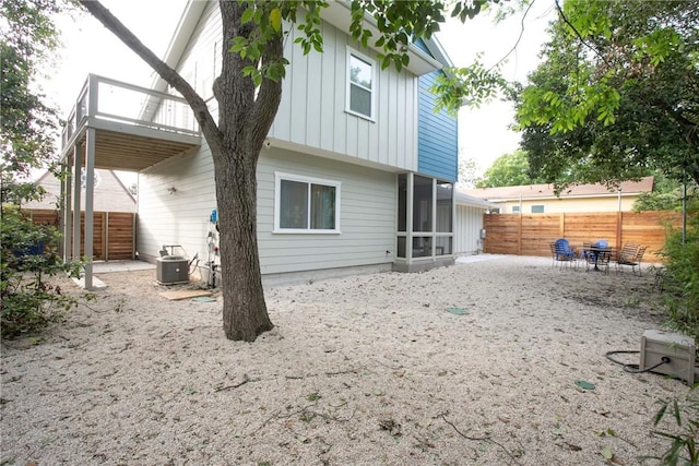 6613 Woodrow Ave, Austin, TX 78757 - rear view of house with a fenced backyard, board and batten siding, a patio area, and a sunroom