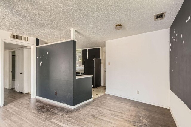 1611 Suffolk Dr, Austin, TX 78723 - unfurnished room featuring wood finished floors and a textured ceiling
