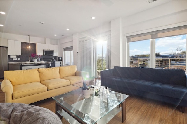 4361 S Congress Ave Unit 209, Austin, TX 78745 - living area featuring healthy amount of natural light, wood finished floors, and recessed lighting