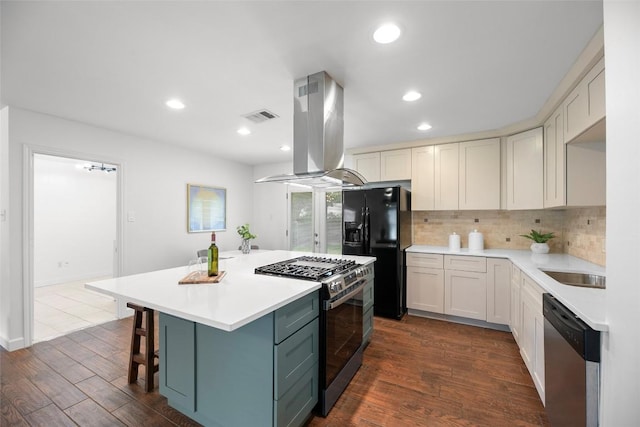 2518 Carlow Dr, Austin, TX 78745 - kitchen with stainless steel appliances, island range hood, tasteful backsplash, dark wood-style flooring, and a kitchen island