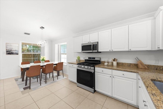 2306 Billy Fiske Ln, Austin, TX 78748 - kitchen featuring stainless steel appliances, white cabinetry, light tile patterned flooring, decorative light fixtures, and ornamental molding