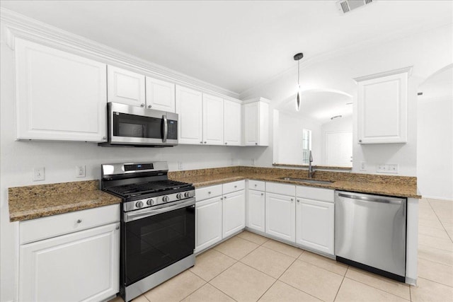 2306 Billy Fiske Ln, Austin, TX 78748 - kitchen featuring appliances with stainless steel finishes, light tile patterned floors, white cabinets, ornamental molding, and arched walkways
