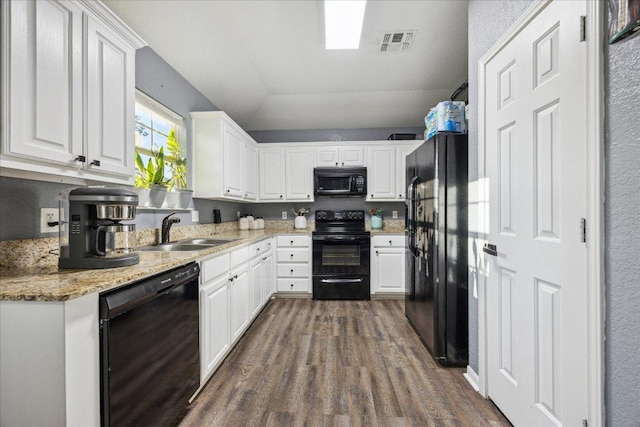1220 Redstone Dr, Temple, TX 76502 - kitchen with black appliances, dark wood-type flooring, white cabinets, and light stone countertops