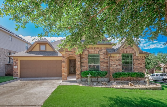 457 Monahans Dr, Georgetown, TX 78628 - view of front of house with an attached garage, a front lawn, driveway, brick siding, and roof with shingles