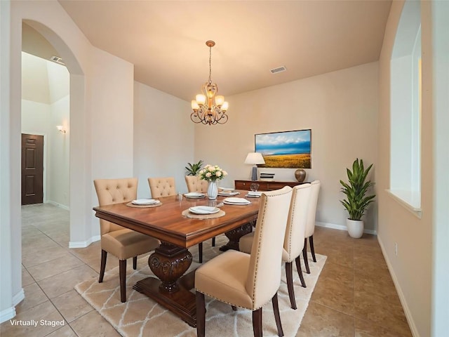 457 Monahans Dr, Georgetown, TX 78628 - dining space featuring arched walkways, light tile patterned floors, and a chandelier