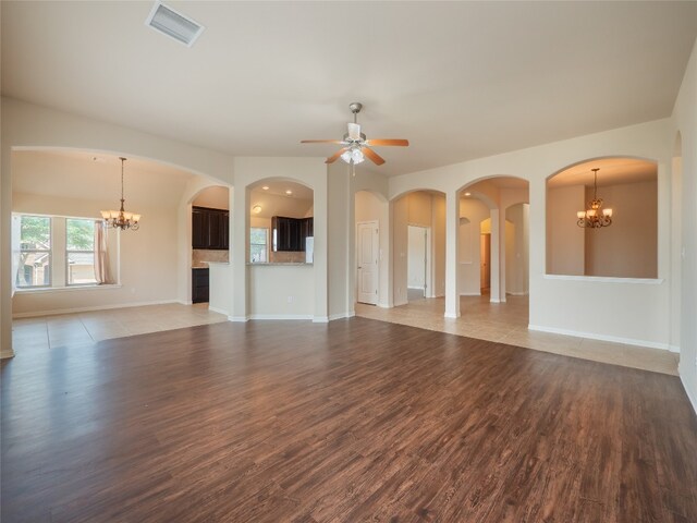 457 Monahans Dr, Georgetown, TX 78628 - unfurnished living room featuring a chandelier, wood finished floors, and a ceiling fan