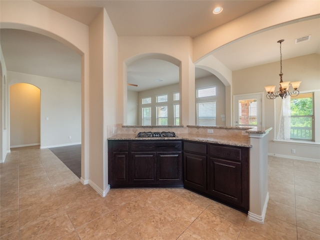 457 Monahans Dr, Georgetown, TX 78628 - kitchen with healthy amount of natural light, light stone counters, arched walkways, a chandelier, and recessed lighting