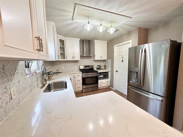 6116 Speyside Dr, Austin, TX 78754 - kitchen featuring stainless steel appliances, wall chimney range hood, backsplash, light stone counters, and white cabinets