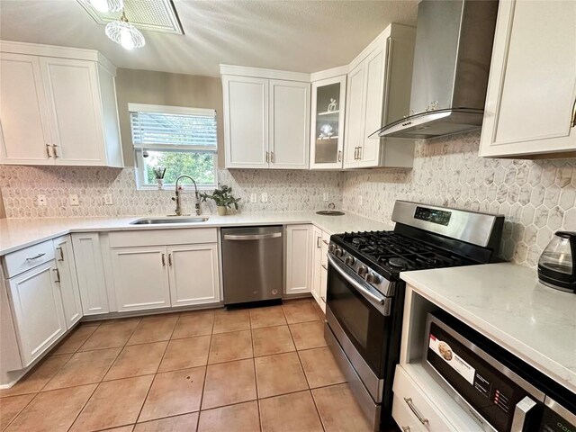 6116 Speyside Dr, Austin, TX 78754 - kitchen with appliances with stainless steel finishes, wall chimney range hood, light tile patterned floors, and white cabinets