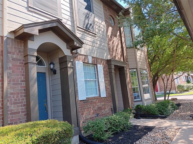 12401 Los Indios Trl Unit 9, Austin, TX 78729 - doorway to property with brick siding