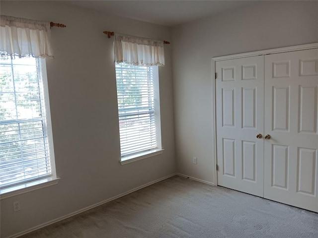 12401 Los Indios Trl Unit 9, Austin, TX 78729 - unfurnished bedroom featuring multiple windows, carpet floors, and a closet