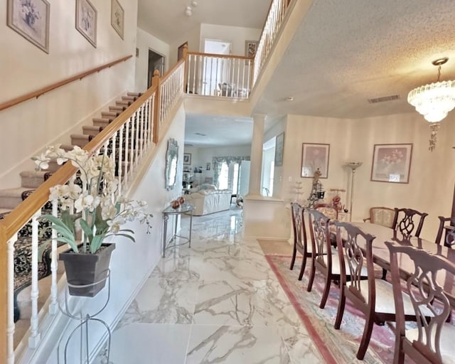 15304 Iola Cv, Austin, TX 78717 - entryway with marble tiled floors, stairway, a chandelier, and ornate columns