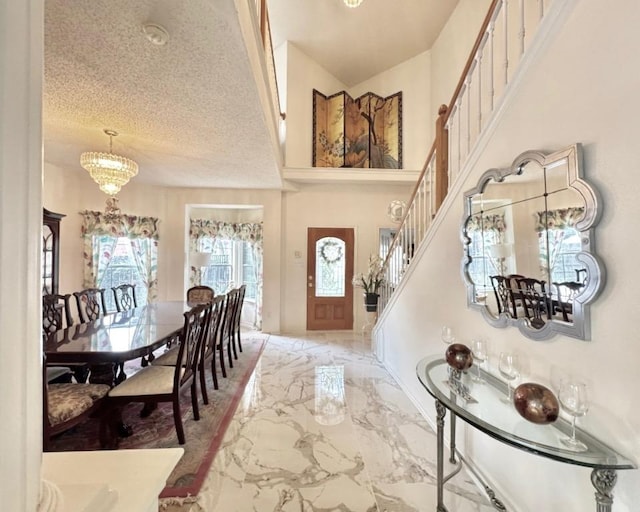 15304 Iola Cv, Austin, TX 78717 - entrance foyer featuring a chandelier, marble tiled floors, stairs, a high ceiling, and a textured ceiling