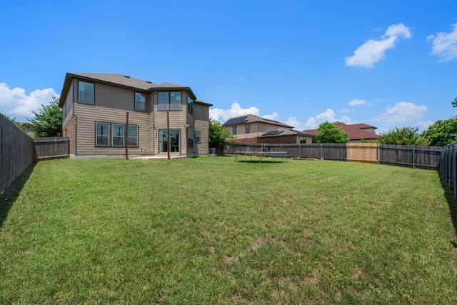 808 Lonesome Lilly Way, Pflugerville, TX 78660 - rear view of house with a trampoline and a fenced backyard