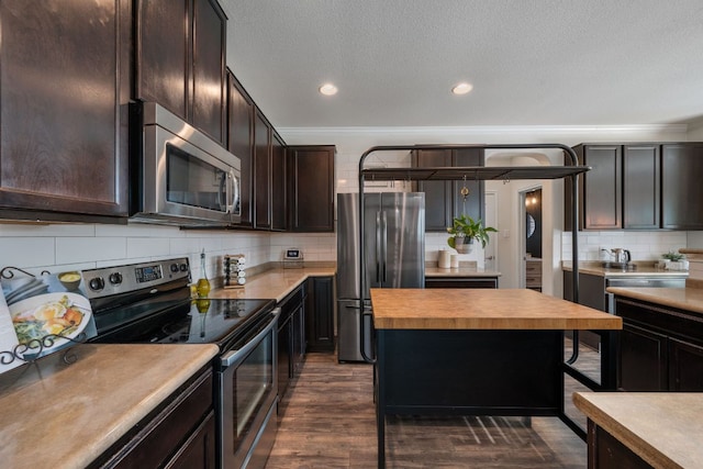 808 Lonesome Lilly Way, Pflugerville, TX 78660 - kitchen with appliances with stainless steel finishes, dark brown cabinetry, tasteful backsplash, dark wood-style flooring, and crown molding