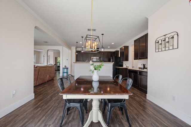 808 Lonesome Lilly Way, Pflugerville, TX 78660 - dining room with dark wood-style floors, crown molding, a chandelier, arched walkways, and recessed lighting