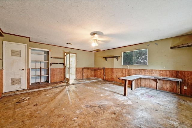 10410 Margra Ln, Austin, TX 78748 - miscellaneous room featuring wainscoting, wooden walls, ceiling fan, a textured ceiling, and crown molding