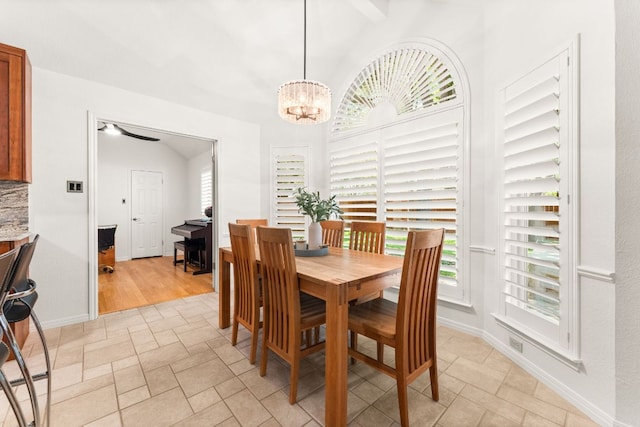 10808 Redmond Rd, Austin, TX 78739 - dining space with lofted ceiling, a chandelier, and light stone finish flooring