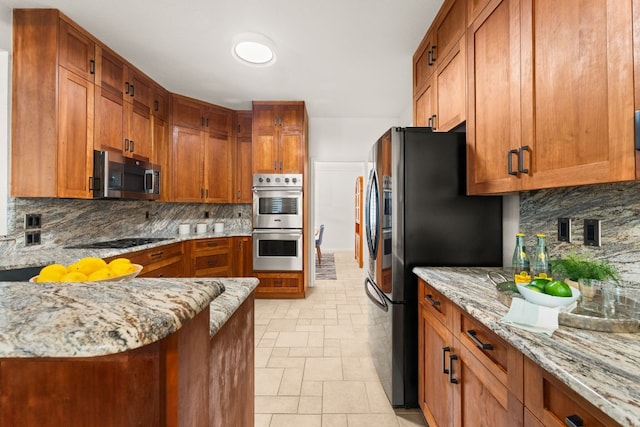 10808 Redmond Rd, Austin, TX 78739 - kitchen featuring stainless steel appliances, backsplash, light stone countertops, and brown cabinetry