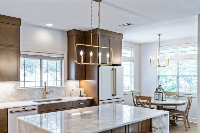3 Stillmeadow Ct, The Hills, TX 78738 - kitchen featuring a chandelier, white appliances, backsplash, decorative light fixtures, and light stone countertops