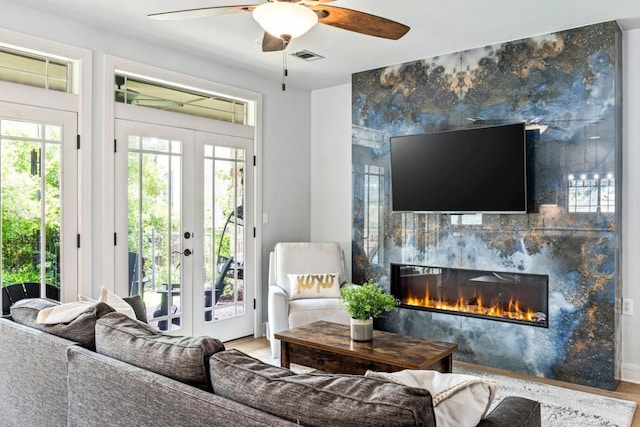 3 Stillmeadow Ct, The Hills, TX 78738 - living room featuring french doors, a fireplace, a ceiling fan, and wood finished floors