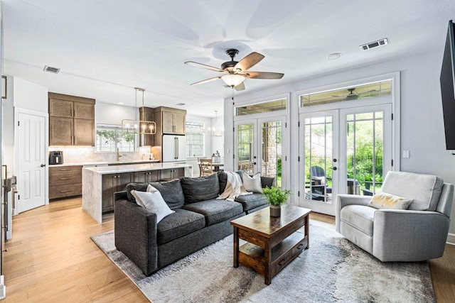 3 Stillmeadow Ct, The Hills, TX 78738 - living area with a ceiling fan, french doors, light wood-type flooring, and a chandelier