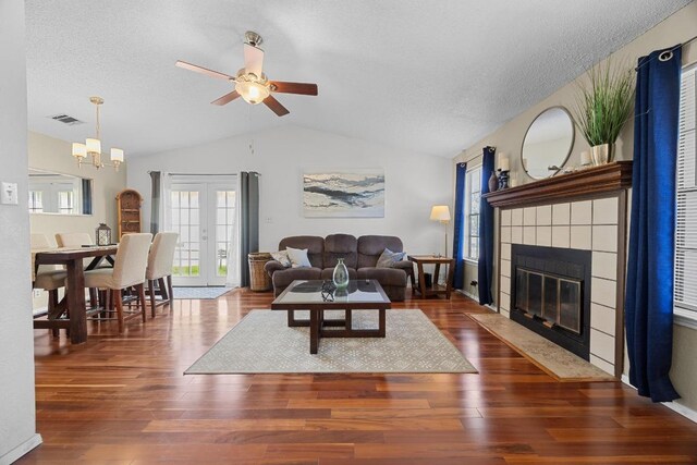 1111 Fairlawn Cv, Round Rock, TX 78664 - living room featuring lofted ceiling, a ceiling fan, wood finished floors, a textured ceiling, and a tile fireplace