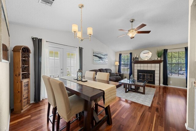 1111 Fairlawn Cv, Round Rock, TX 78664 - dining space featuring dark wood finished floors, lofted ceiling, a ceiling fan, a fireplace, and a textured ceiling