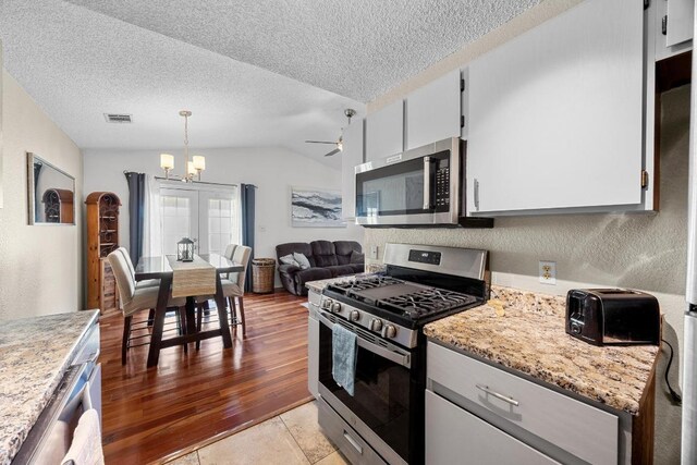 1111 Fairlawn Cv, Round Rock, TX 78664 - kitchen featuring appliances with stainless steel finishes, a chandelier, a textured ceiling, lofted ceiling, and a ceiling fan