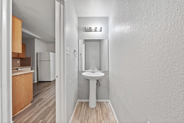 204 Meadowview Ln, Gatesville, TX 76528 - bathroom with a textured wall, wood finished floors, and backsplash