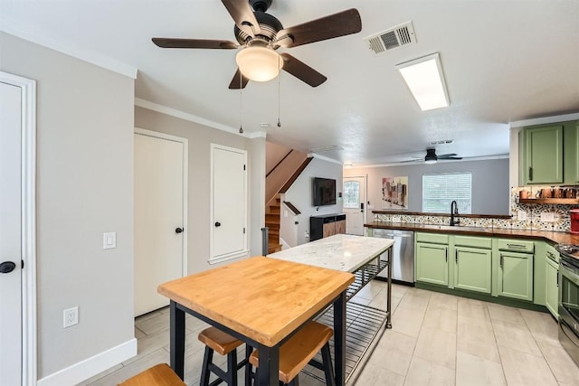 17729 Golden Valley Dr, Manor, TX 78653 - kitchen with green cabinetry, stainless steel appliances, ceiling fan, a peninsula, and crown molding