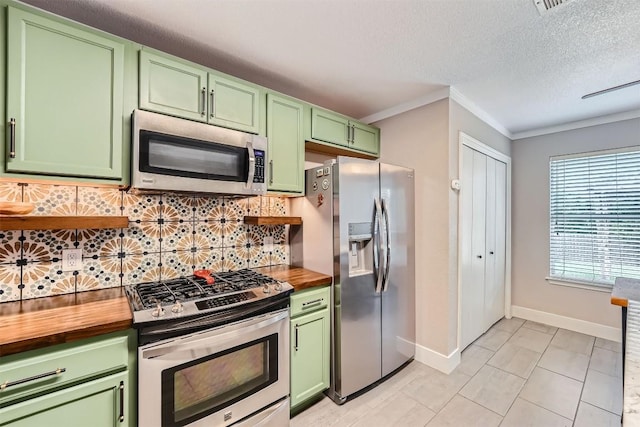 17729 Golden Valley Dr, Manor, TX 78653 - kitchen with stainless steel appliances, green cabinets, wooden counters, ornamental molding, and backsplash