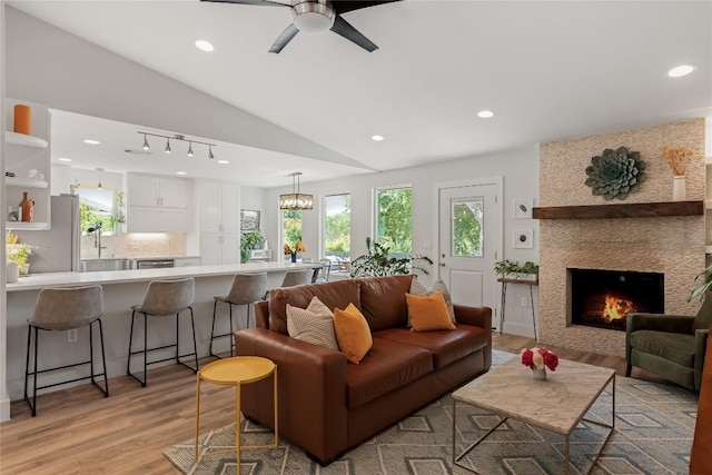 7619 Scenic Brook Dr, Austin, TX 78736 - living area with light wood-style floors, ceiling fan, vaulted ceiling, recessed lighting, and a large fireplace