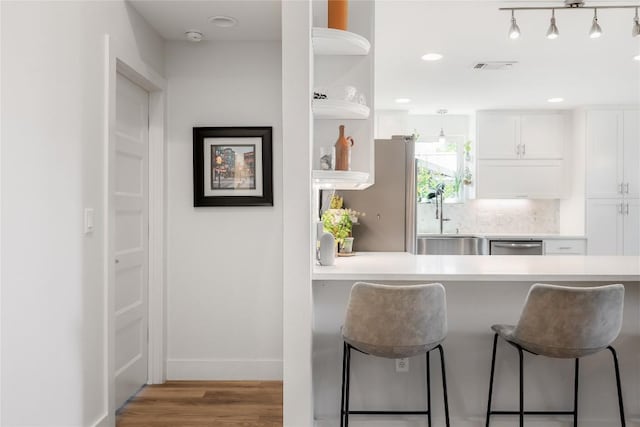 7619 Scenic Brook Dr, Austin, TX 78736 - kitchen with white cabinetry, light wood-style flooring, a breakfast bar area, light countertops, and open shelves